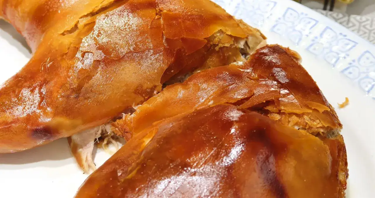 Un crujiente cochinillo al horno, con piel dorada y carne jugosa, listo para ser disfrutado en una celebración.