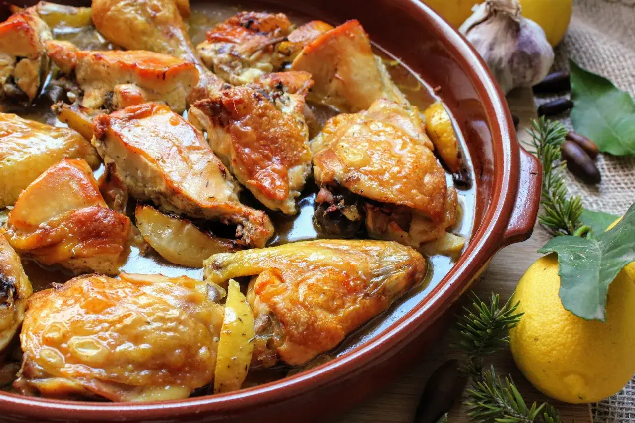 Pollo al limón, receta de la abuela, jugoso y dorado en cazuela de barro con limones y romero.
