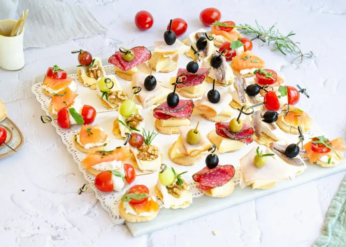 Canapés fríos fáciles y baratos: salmón, queso, embutidos, aceitunas y tomates cherry sobre pan crujiente. ¡Perfectos para cualquier ocasión!