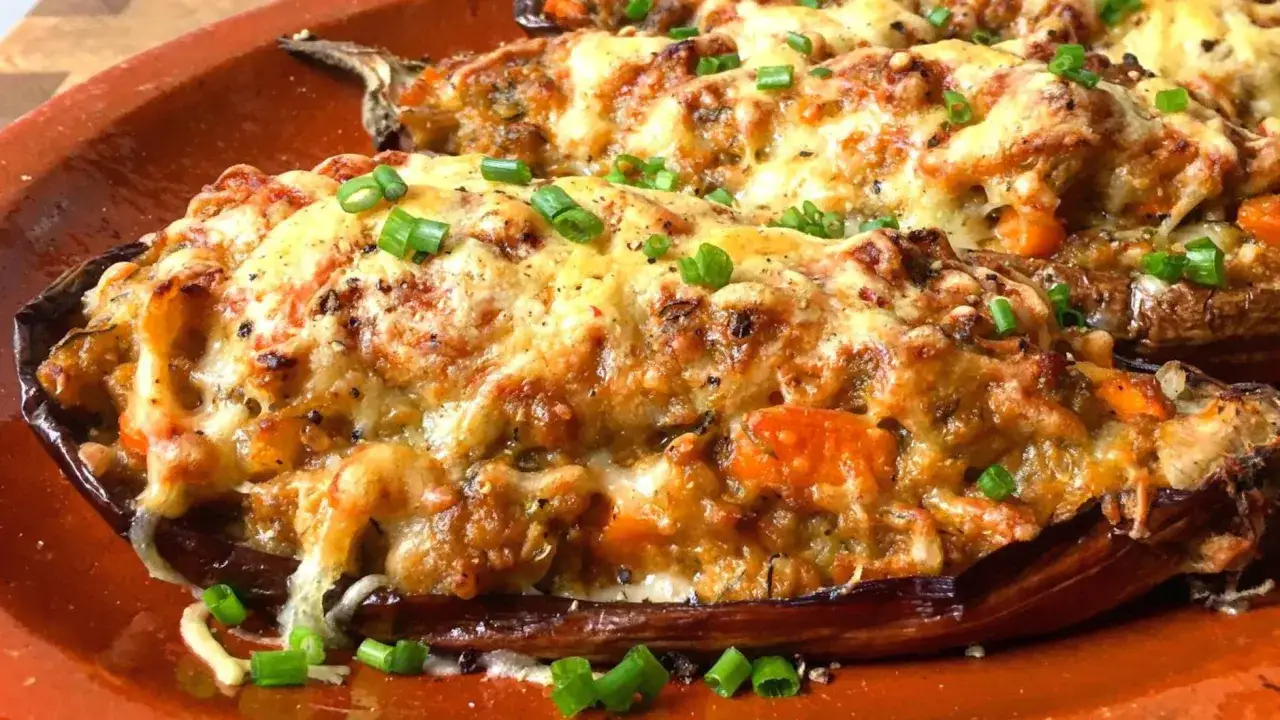 Berenjenas rellenas gratinadas con queso y cebolleta, preparadas en airfryer. &iexcl;Un plato delicioso y f&aacute;cil!