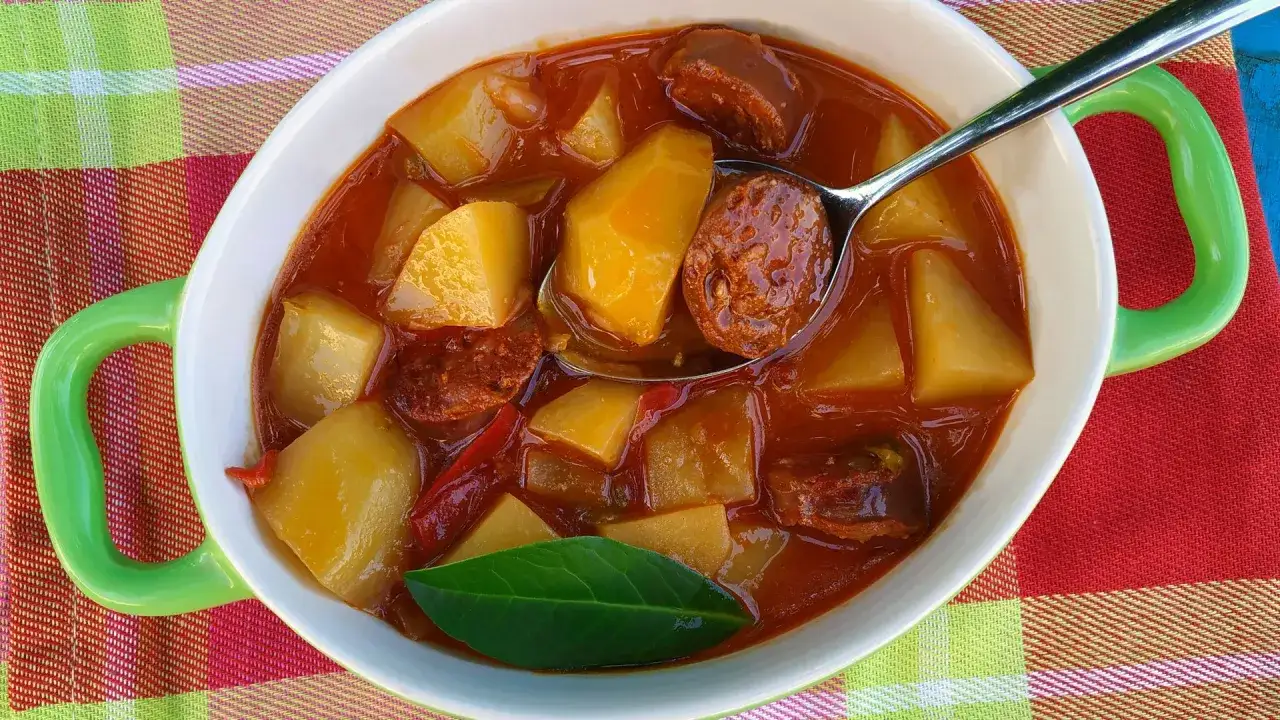 Un plato humeante de patatas a la riojana, con trozos de chorizo y patata en una salsa roja.