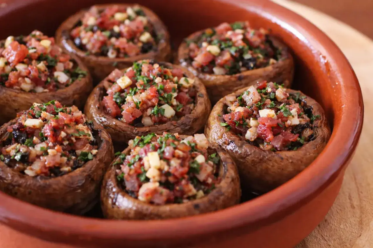 Champi&ntilde;ones rellenos de jam&oacute;n, ajo y perejil, horneados hasta la perfecci&oacute;n. &iexcl;Un bocado delicioso!