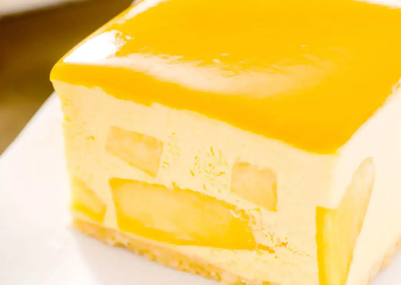 Delicioso mousse de mango con trozos de fruta y un glaseado brillante.