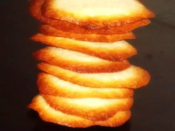 Torre de crujientes galletas de coco, doradas y apetitosas, apiladas unas sobre otras.