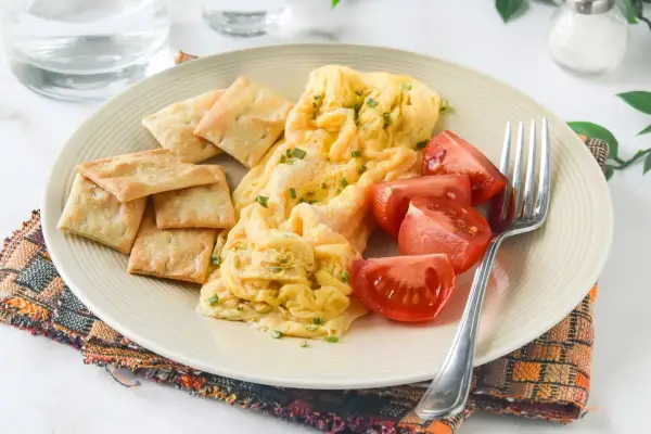Tortilla francesa en microondas con galletas saladas y tomates. Un desayuno rápido y fácil.