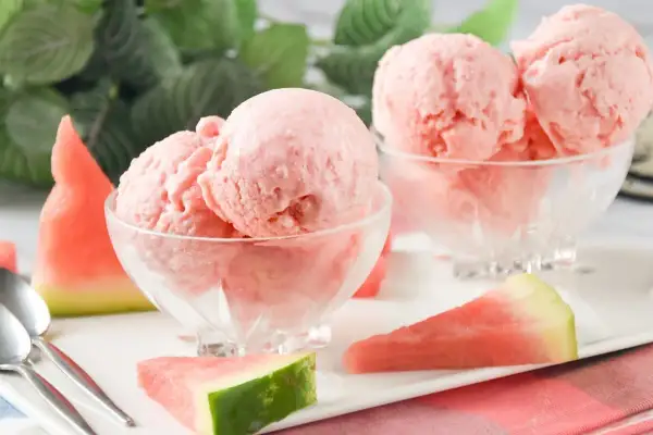 Delicioso helado de sandía casero en copas de cristal, acompañado de trozos de sandía fresca. ¡Un postre refrescante!