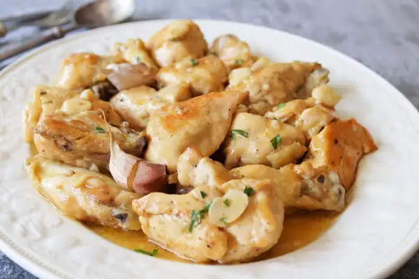 Saborea el pollo al limón receta de la abuela, jugoso y con un toque de ajo, servido en un plato blanco.