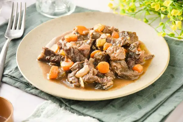 Tierna ternera en salsa con zanahorias y cebolla, un plato reconfortante y sabroso.